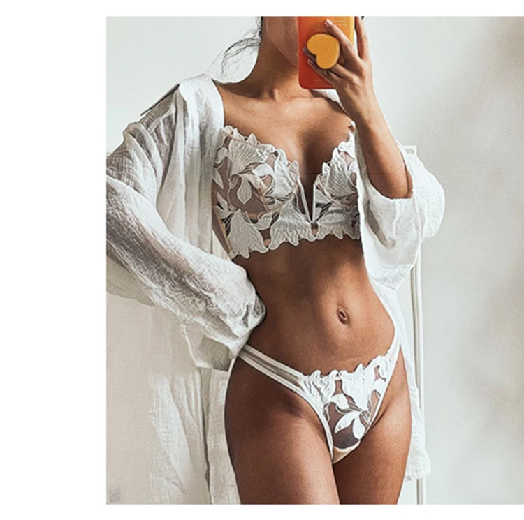 Frau trägt zartes weißes Dessous-Set mit weißem Überwurf